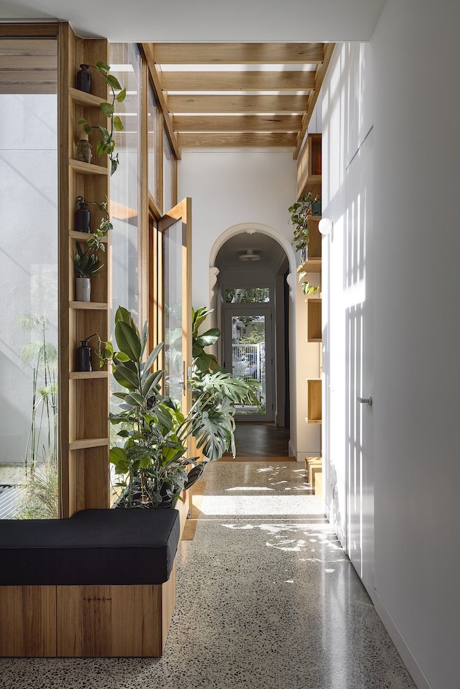 picture of the interior of a house with plants and wooden parts