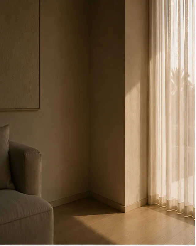 A shadowed interior corner of a Dubai villa where two plaster walls meet.